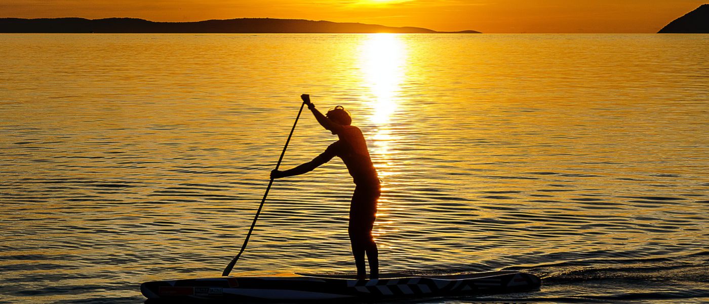 Stand-up Paddeln im Sonnenuntergang (Photo: by Damir Spanic on Unsplash)