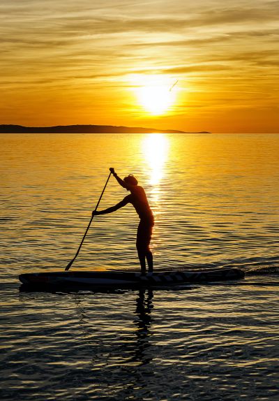 Stand-up Paddeln im Sonnenuntergang (Photo: by Damir Spanic on Unsplash)